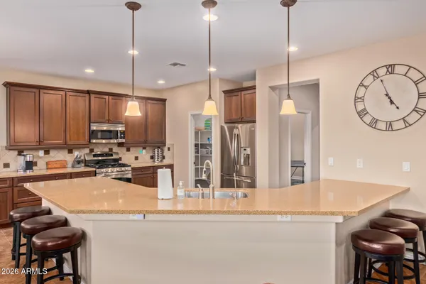 a kitchen with stainless steel appliances granite countertop a sink a stove and a wooden floor