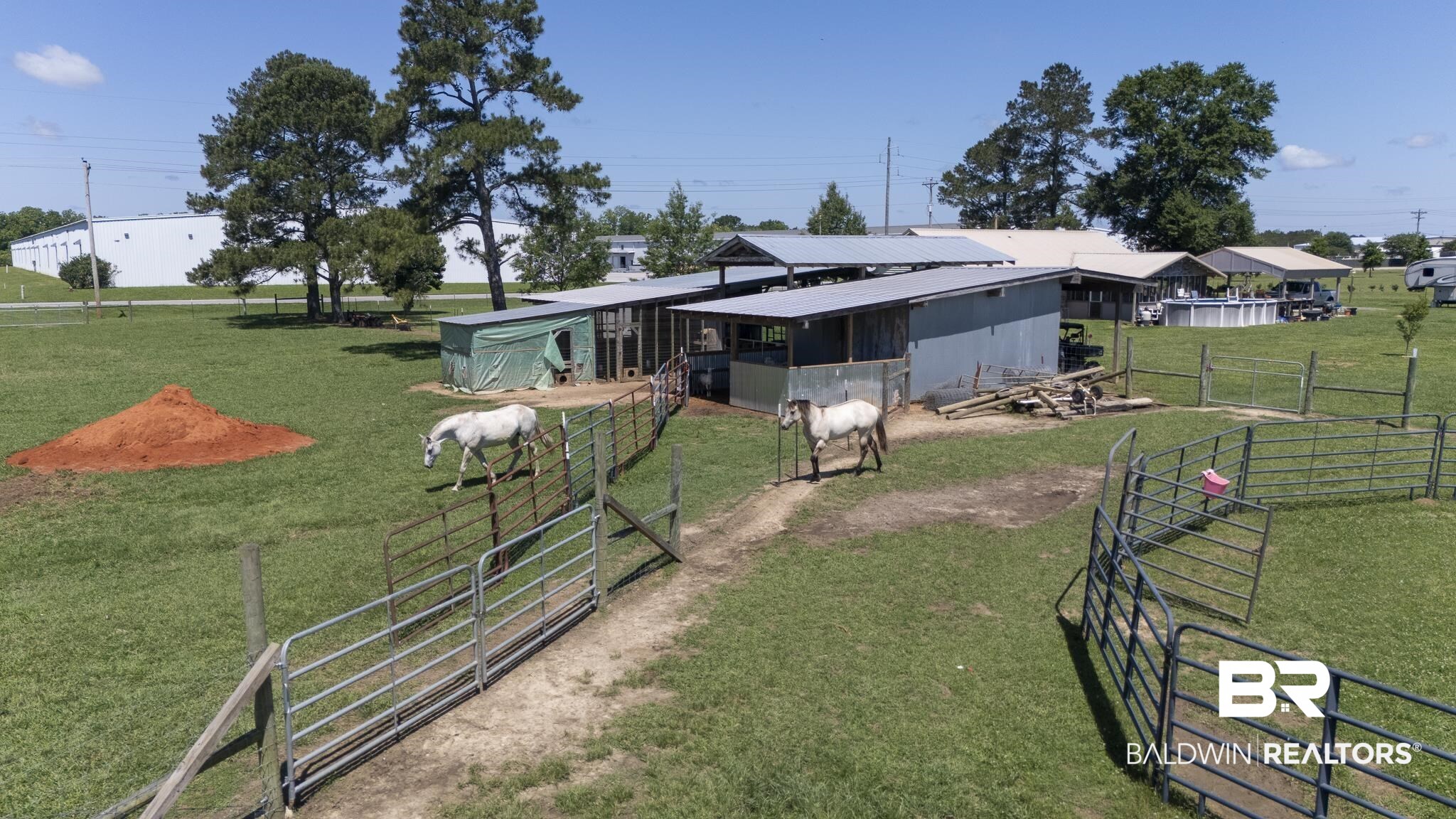 30580 County Road 49 Loxley, AL 36551 - Photo 29 of 32 Expansive green pasture with multiple fenced enclosures and a large barn structure