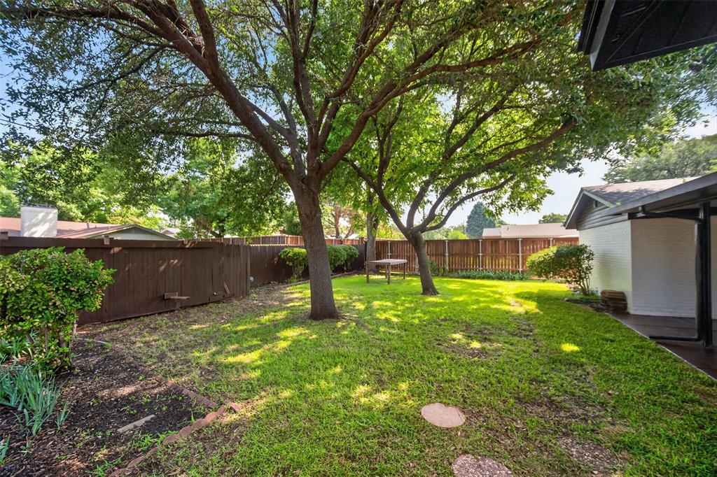 3919 Ridgeoak Way Farmers Branch, TX 75244 - Photo 27 of 28 Spacious backyard featuring established trees, a grassy lawn, and a privacy fence