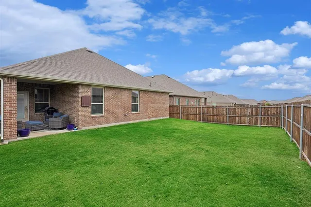a view of a yard with wooden fence