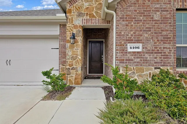 a stone house with potted plants in front of door