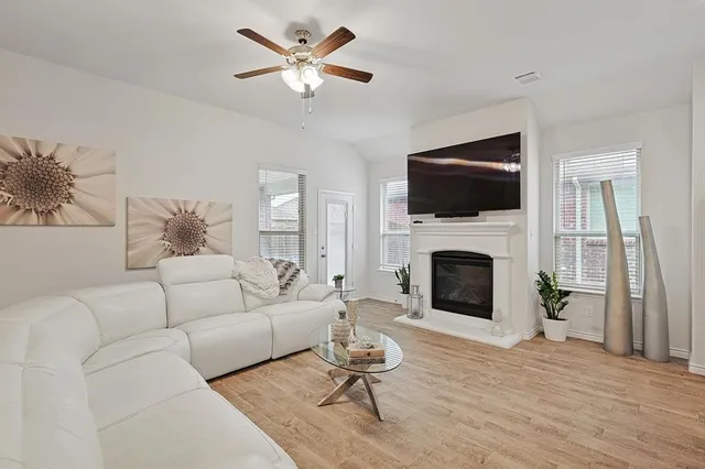 a living room with furniture and a large mirror with wooden floor