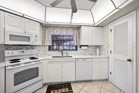 a kitchen with white cabinets and appliances