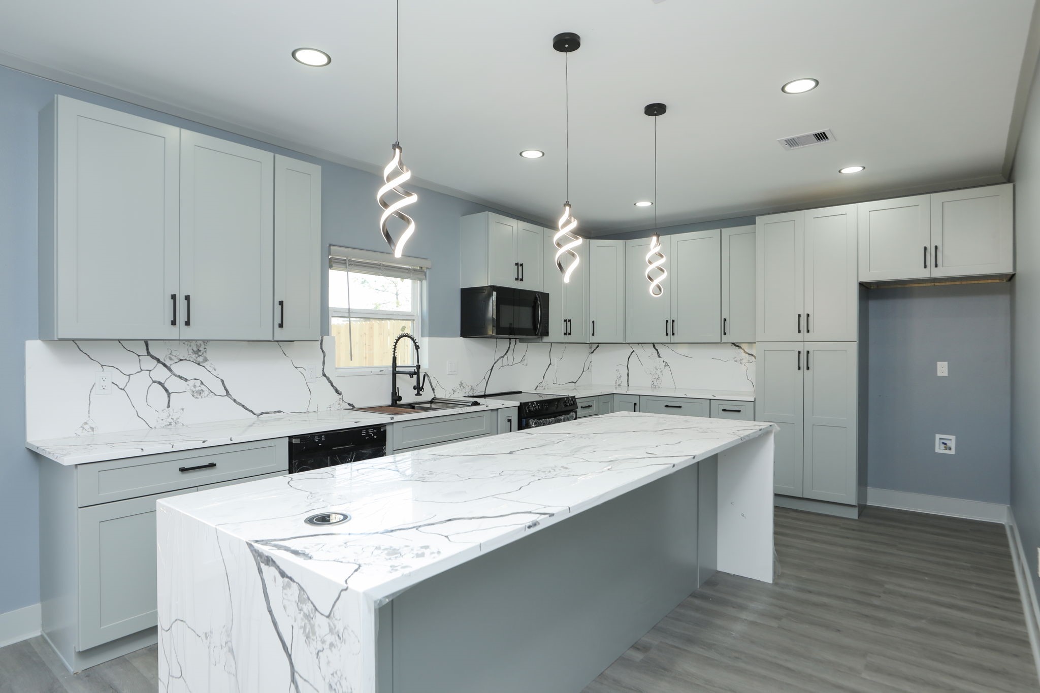 4047 Juliet Street Houston, TX 77087 - Photo 15 of 38 a kitchen with kitchen island a sink stainless steel appliances and wooden floor