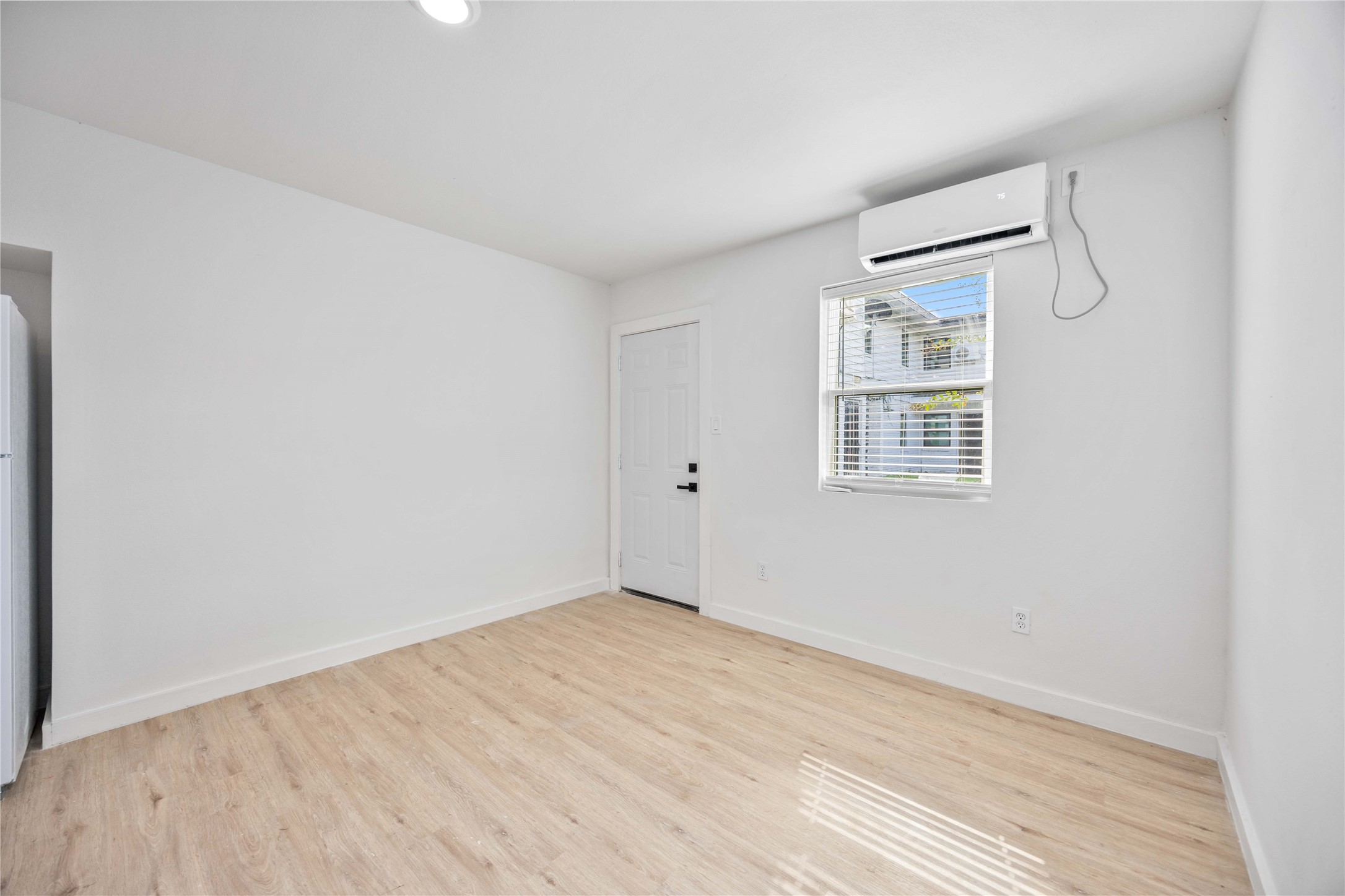 6811 Del Rio Street, Unit 26 Houston, TX 77021 - Photo 4 of 18 a view of an empty room with wooden floor and a window