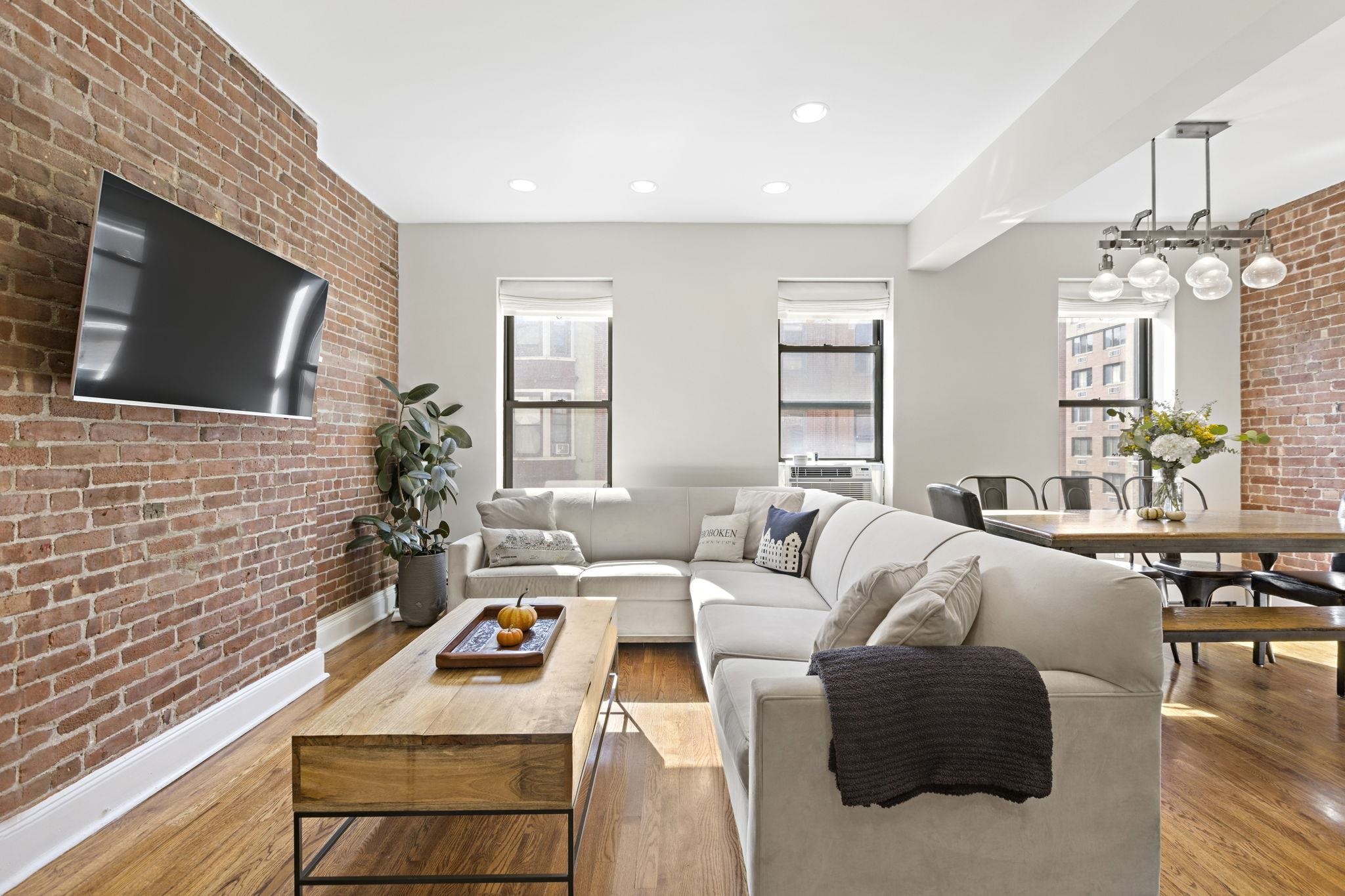 262 1st Street, Unit D Hoboken, NJ 07030 - Photo 4 of 19 a living room with furniture and a flat screen tv