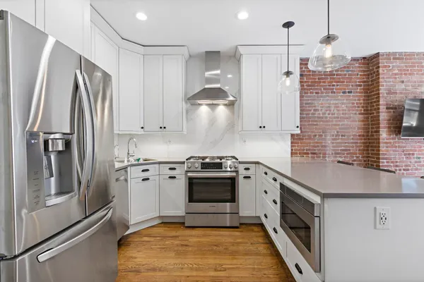 a kitchen with stainless steel appliances granite countertop a stove a refrigerator and a sink