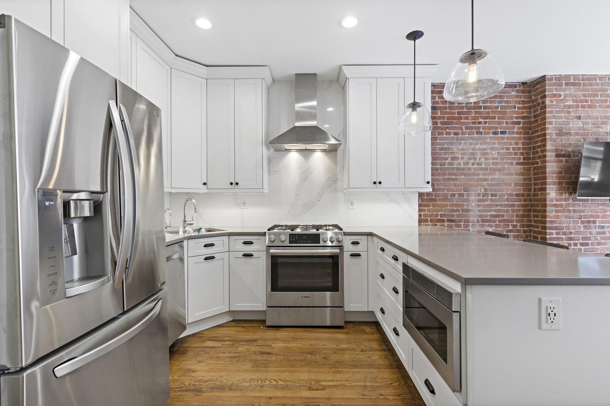 262 1st Street, Unit D Hoboken, NJ 07030 - Photo 6 of 19 a kitchen with stainless steel appliances granite countertop a stove a refrigerator and a sink