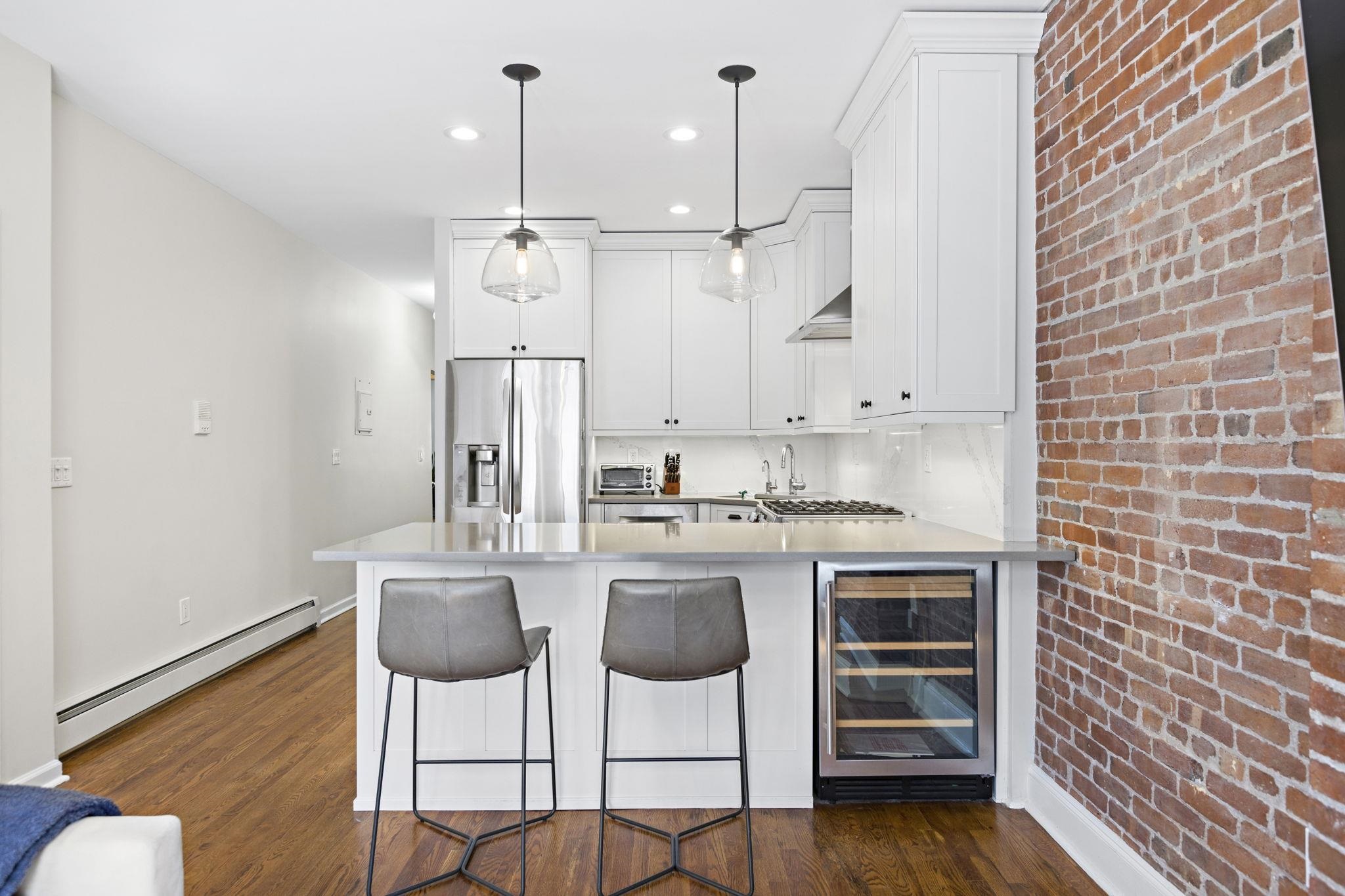 262 1st Street, Unit D Hoboken, NJ 07030 - Photo 8 of 19 a kitchen with stainless steel appliances granite countertop a sink a stove a refrigerator and island with wooden floor