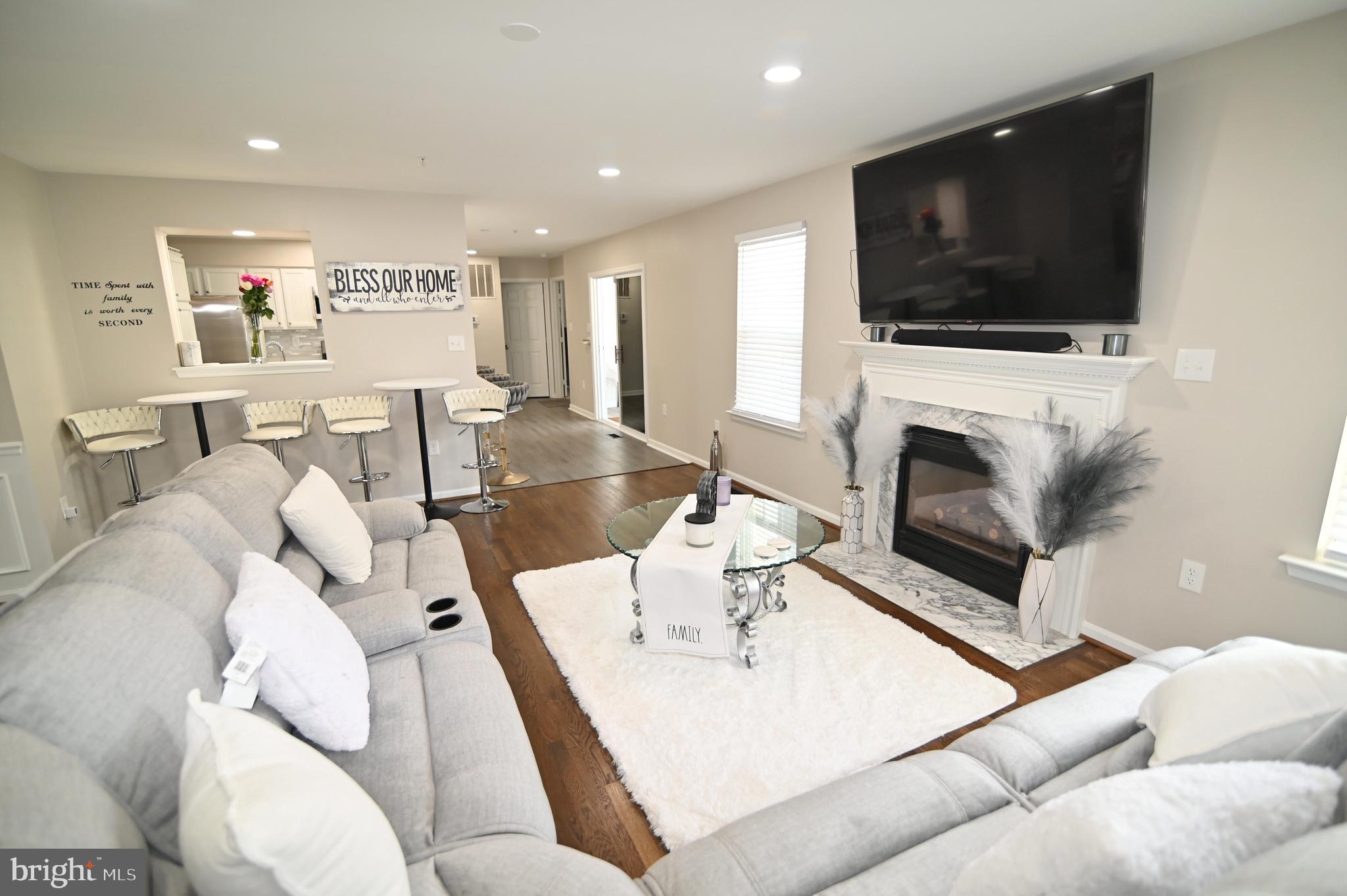 6009 Sellner Lane Clinton, MD 20735 - Photo 15 of 61 a living room with furniture a flat screen tv and a fireplace