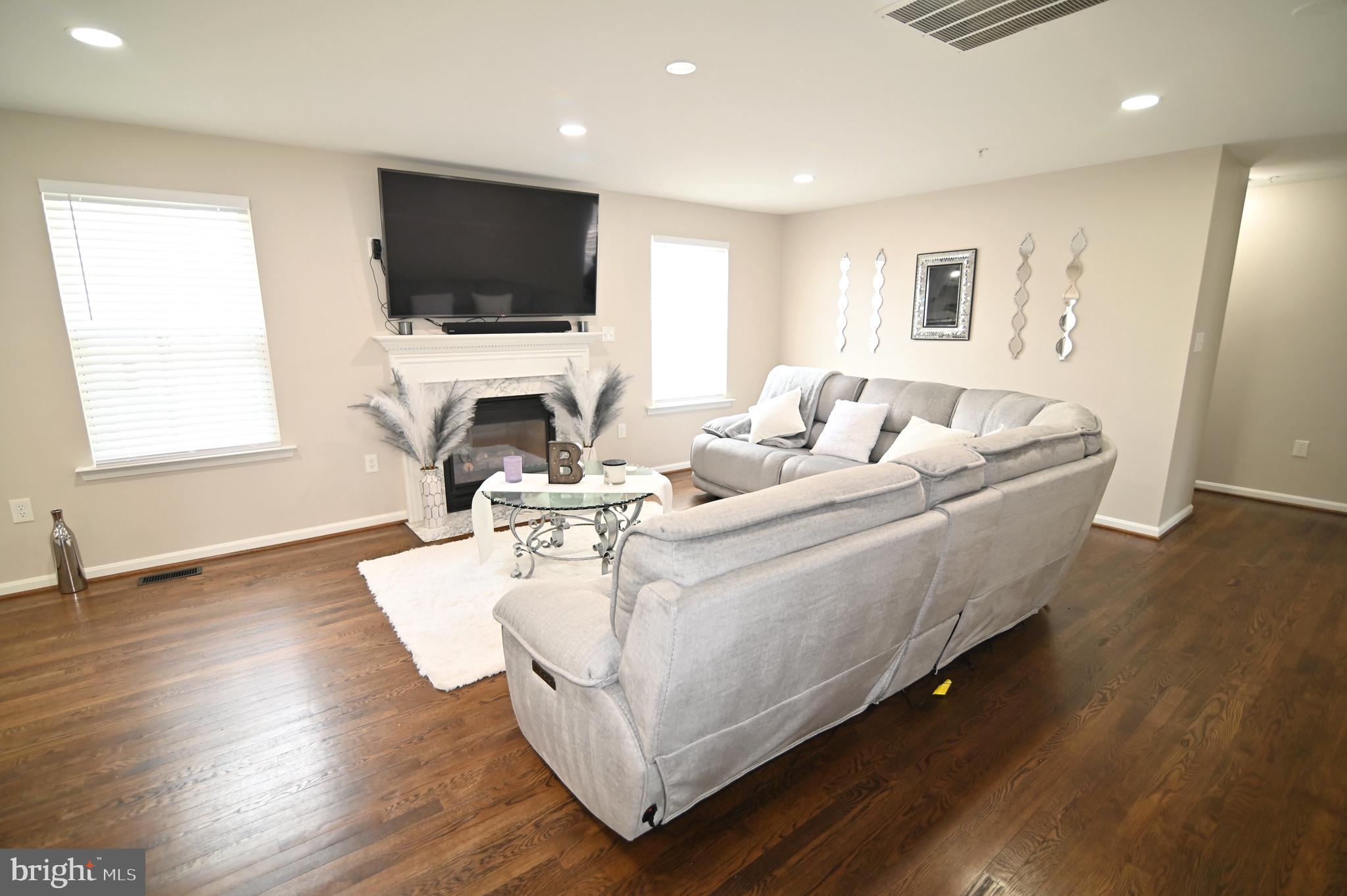 6009 Sellner Lane Clinton, MD 20735 - Photo 18 of 61 a living room with furniture a fireplace and a flat screen tv