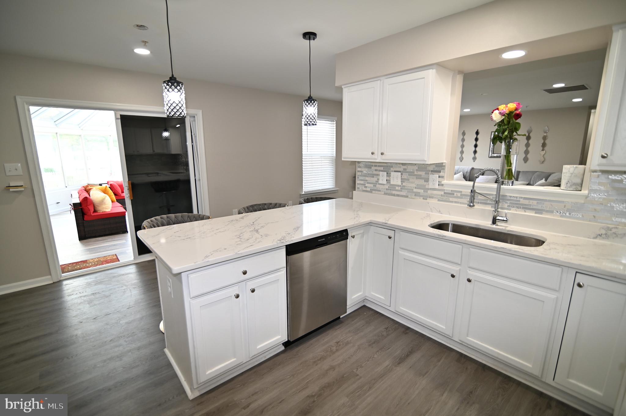 6009 Sellner Lane Clinton, MD 20735 - Photo 20 of 61 a kitchen with a sink dishwasher and white cabinets with wooden floor