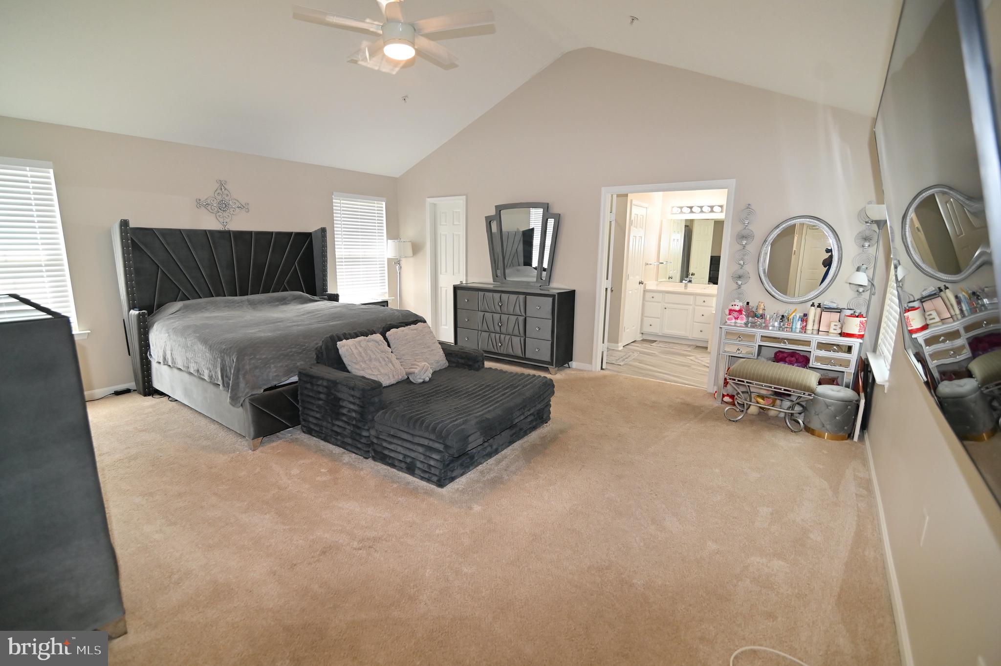 6009 Sellner Lane Clinton, MD 20735 - Photo 29 of 61 a spacious bedroom with a bed a mirror and lamp on desk