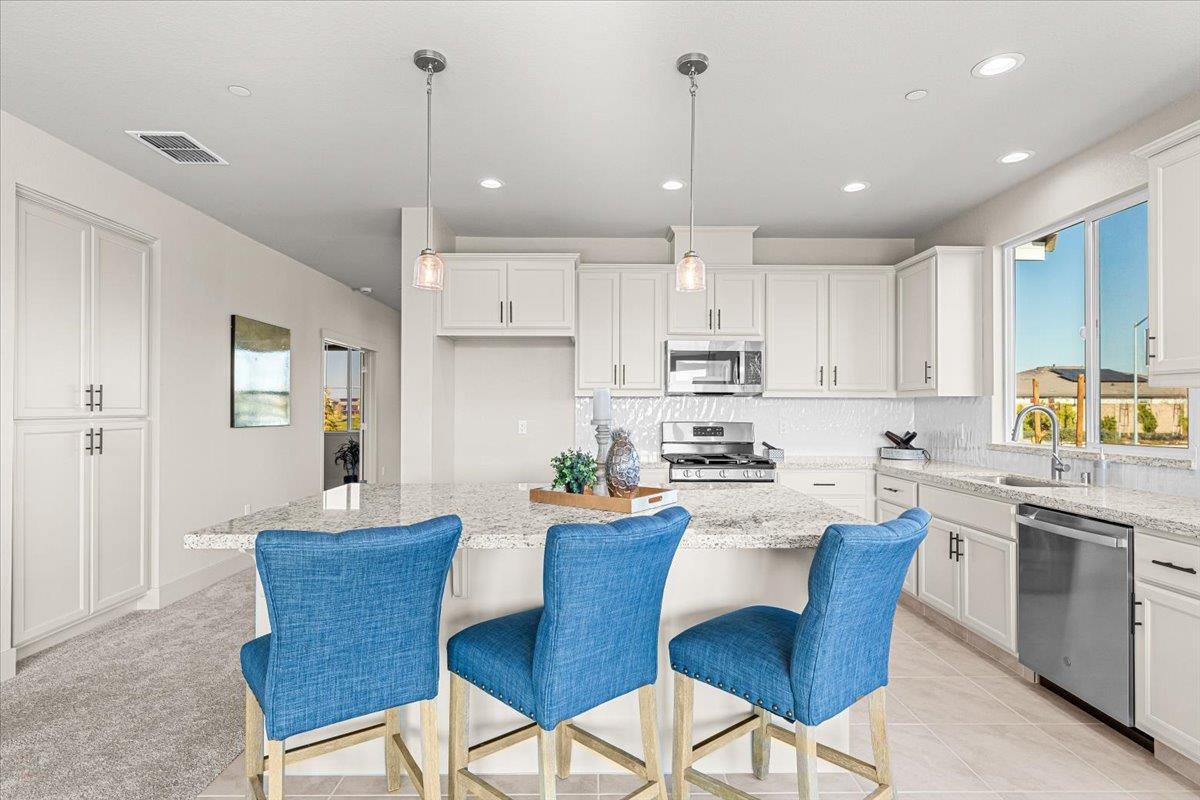 2970 East Tuolumne Road Turlock, CA 95382 - Photo 24 of 68 kitchen featuring a kitchen breakfast bar, a center island, decorative light fixtures, appliances with stainless steel finishes, and recessed lighting