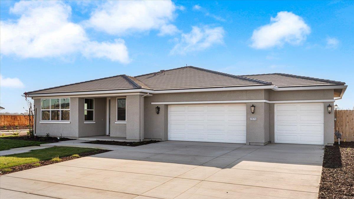2970 East Tuolumne Road Turlock, CA 95382 - Photo 3 of 68 a front view of a house with a yard and garage
