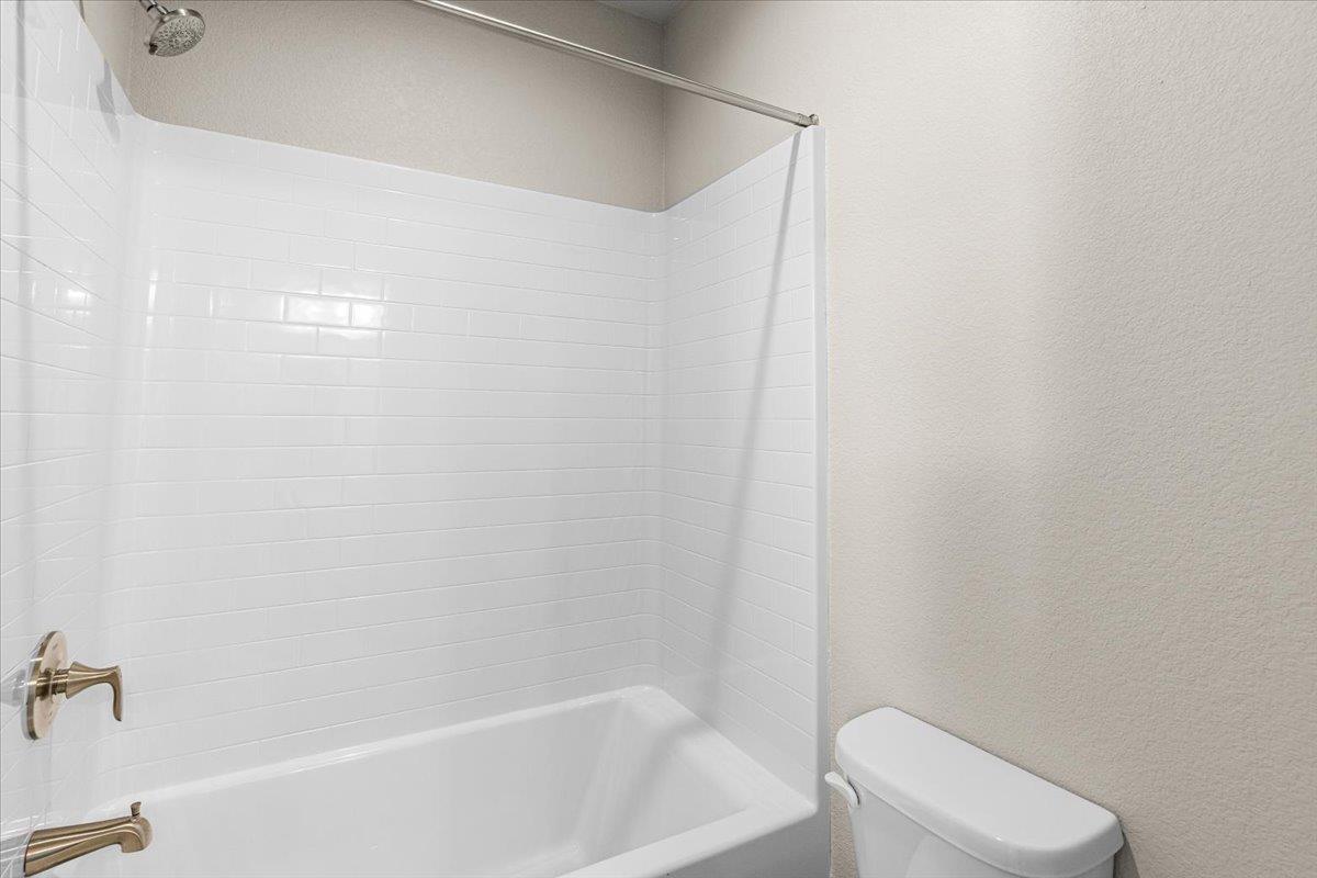 2970 East Tuolumne Road Turlock, CA 95382 - Photo 45 of 68 a white bath tub sitting next to a white toilet and vanity