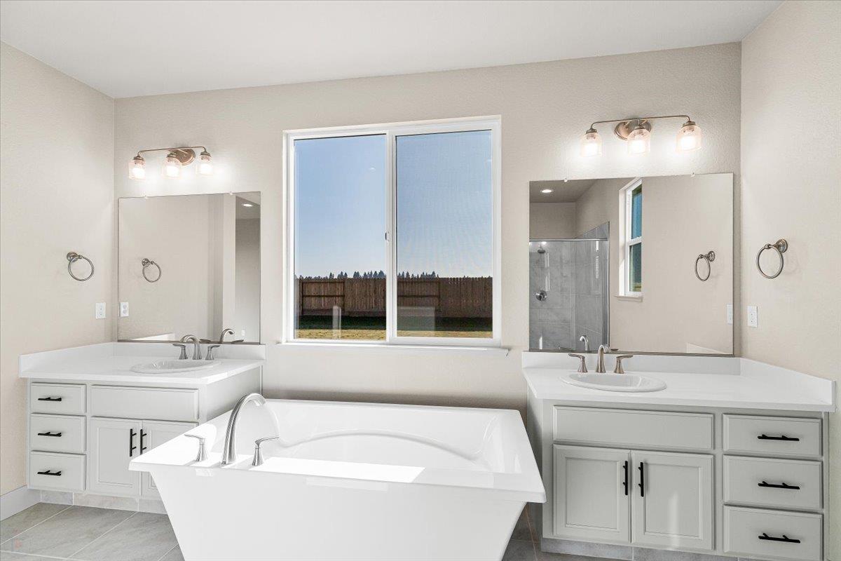 2970 East Tuolumne Road Turlock, CA 95382 - Photo 61 of 68 a bathroom with a tub double sink and mirror