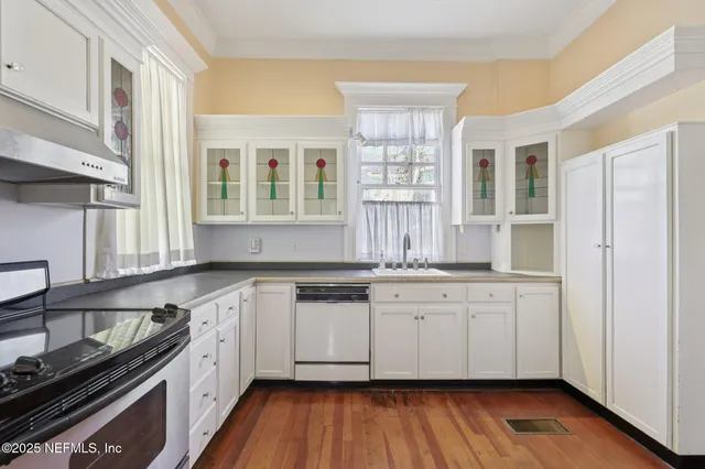a bed sitting in a bedroom next to a window with a painting on the wall