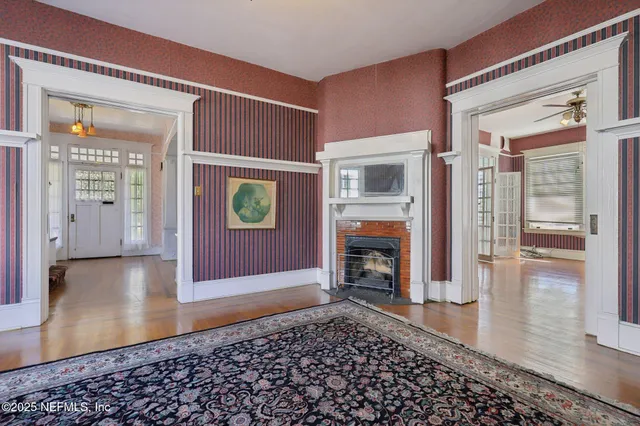 a view of a livingroom with wooden floor and a fireplace