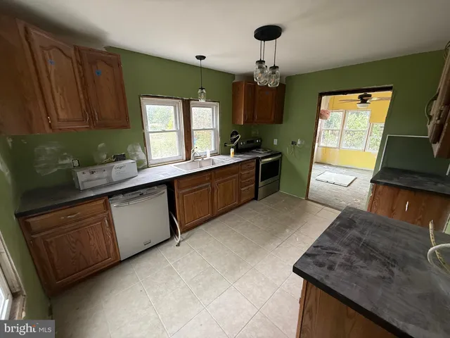 a kitchen with granite countertop sink stove and cabinets
