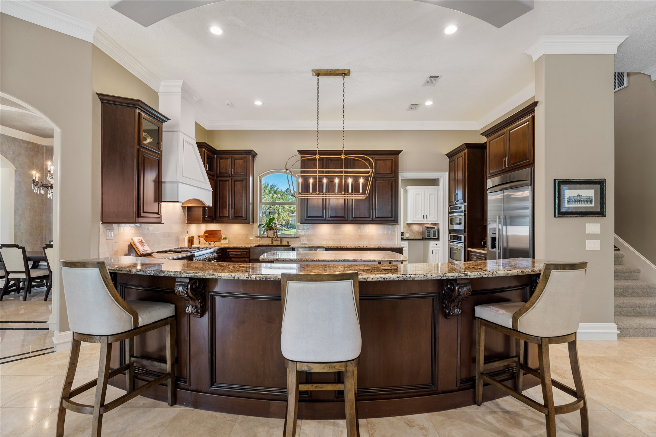 82 Manor Lake Estates Circle Spring, TX 77379 - Photo 17 of 50 This front facing view of the kitchen highlights its commanding center island, elegant lighting, and substantial storage. It is a true anchor of the home, designed for both elevated everyday living and large scale hosting.