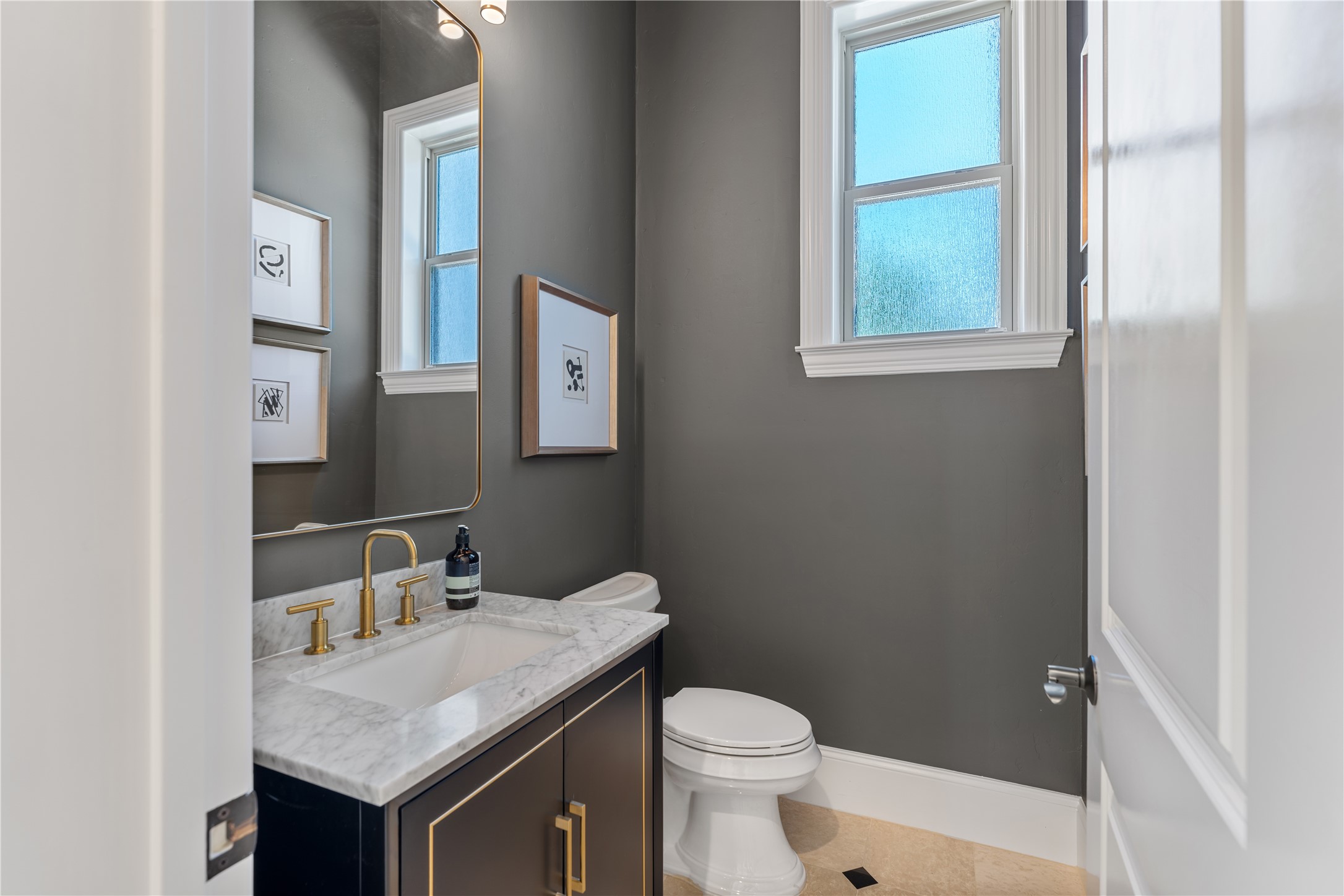 82 Manor Lake Estates Circle Spring, TX 77379 - Photo 23 of 50 The powder bath has been beautifully reimagined with a more tailored, contemporary look, featuring striking contrast tones, marble surfaces, and warm metallic accents. It delivers the kind of thoughtful finish level luxury buyers notice immediately.
