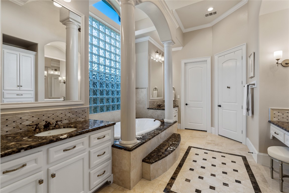82 Manor Lake Estates Circle Spring, TX 77379 - Photo 26 of 50 From this angle, the scale and elegance of the primary bath come through beautifully, with generous cabinetry, rich stone surfaces, and a refined arrangement that feels both luxurious and functional. It is a space designed for comfort, routine, and relaxation at a high level.