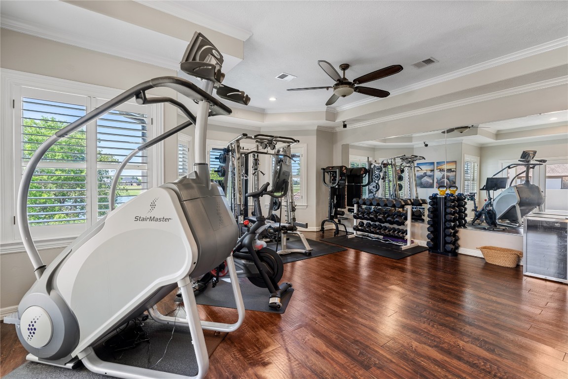 82 Manor Lake Estates Circle Spring, TX 77379 - Photo 31 of 50 The upstairs flex room is currently used as a gym making it a standout lifestyle feature, offering ample room for cardio, strength training, and a full home wellness setup. Wood flooring, mirrored walls, and generous natural light make the space feel energized and highly functional.