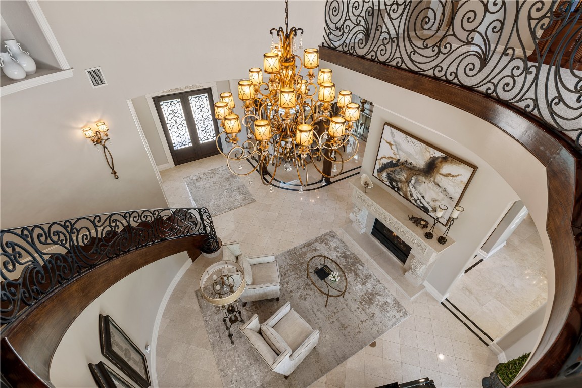 82 Manor Lake Estates Circle Spring, TX 77379 - Photo 8 of 50 From above, the living room becomes a true architectural showpiece, framed by the dramatic curved staircase and an impressive chandelier suspended over the two story volume. This vantage point captures the scale, artistry, and elegance that define the home’s central gathering space. The Chandelier also is on an automatic cable to lower for easy cleaning and maintenance.