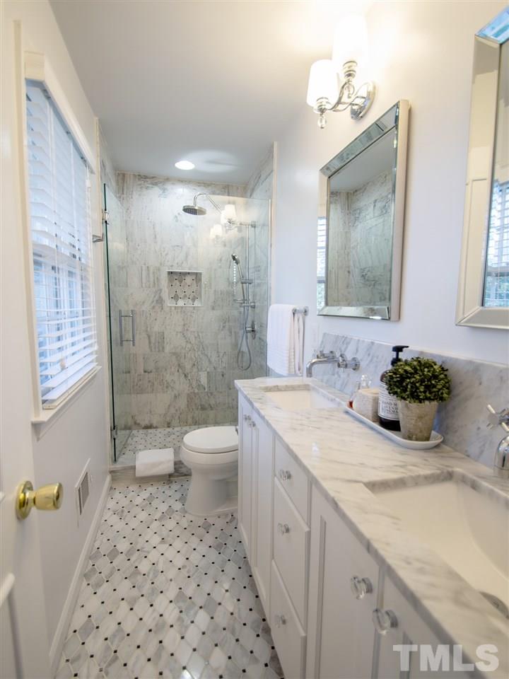 2324 Ridge Road Raleigh, NC 27612 - Photo 17 of 25 a bathroom with a granite countertop sink toilet a large mirror a shower and a bathtub