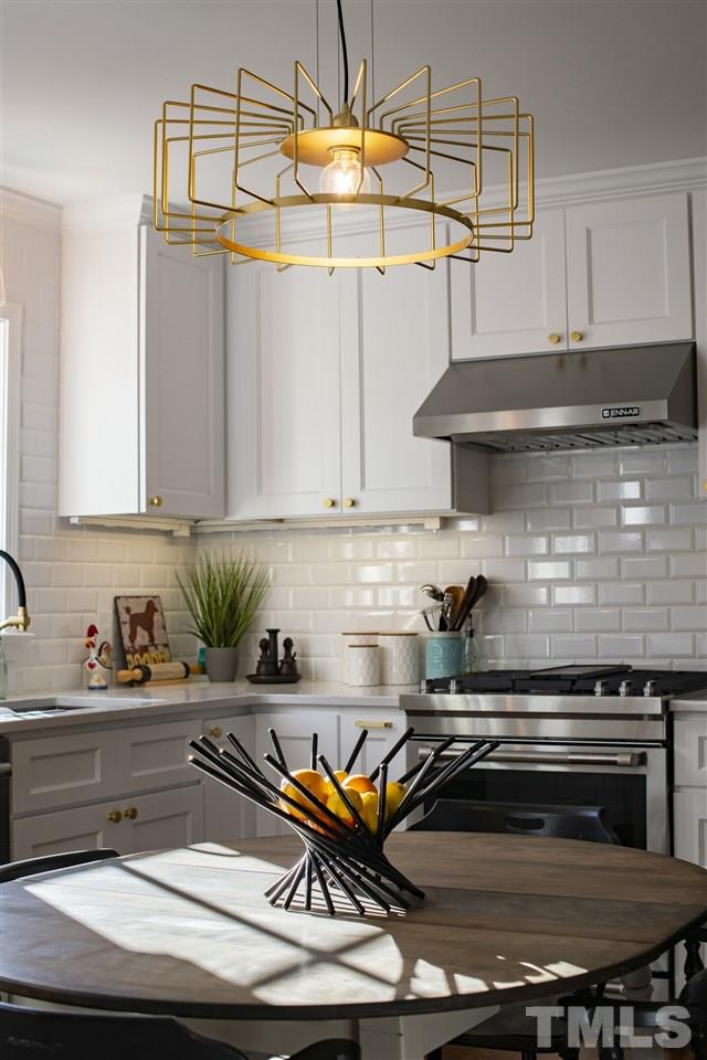 2324 Ridge Road Raleigh, NC 27612 - Photo 9 of 25 a kitchen with a stove and a white wooden cabinets