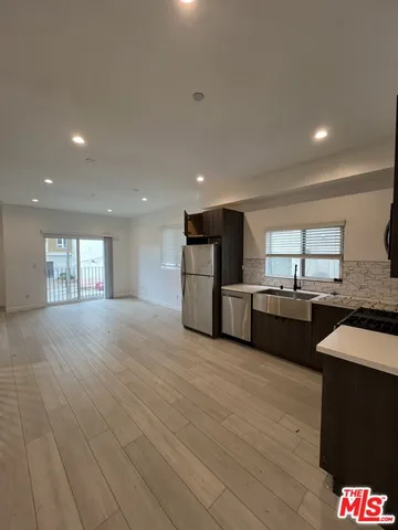 a large kitchen with stainless steel appliances kitchen island granite countertop a sink and cabinets