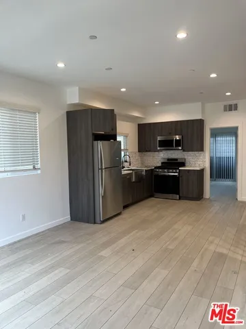 a view of kitchen with refrigerator and microwave