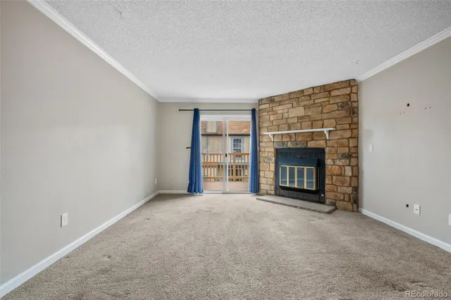 a view of an empty room with a fireplace and a window
