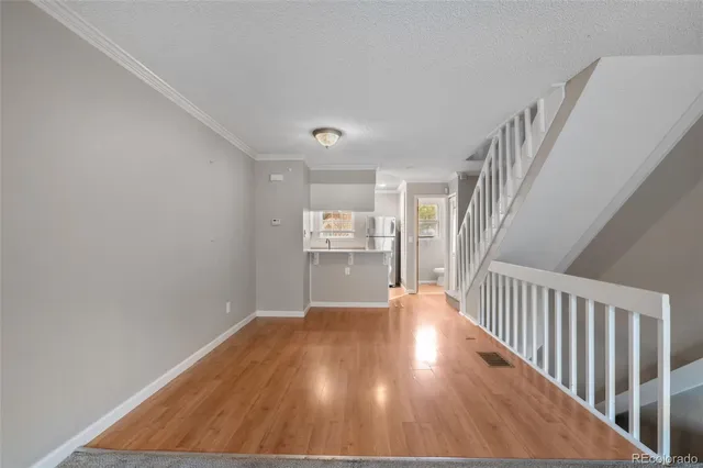 a view of a hallway with wooden floor and stairs
