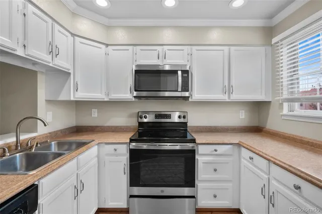 a kitchen with granite countertop white cabinets and stainless steel appliances