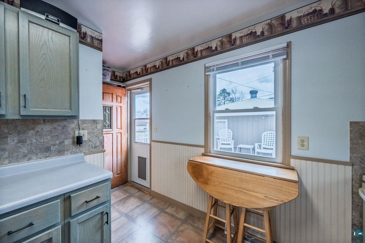 319 Michigan Avenue West Gilbert, MN 55741 - Photo 11 of 48 Kitchen space featuring light-toned cabinetry, light-colored countertops, and a stone-look backsplash