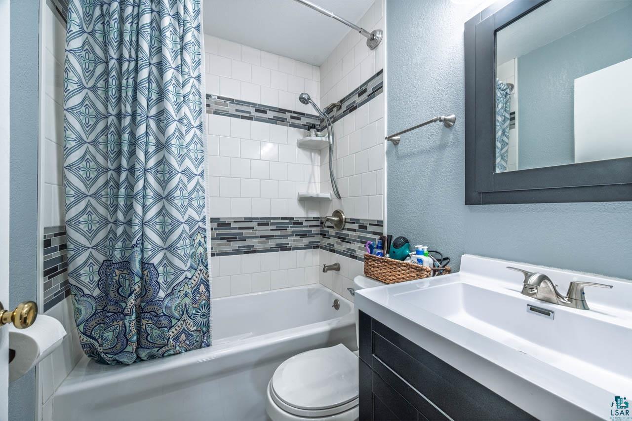 319 Michigan Avenue West Gilbert, MN 55741 - Photo 15 of 48 Bathroom featuring a white subway tile shower with a mosaic accent band, a built-in shower caddy, and a brushed nickel showerhead