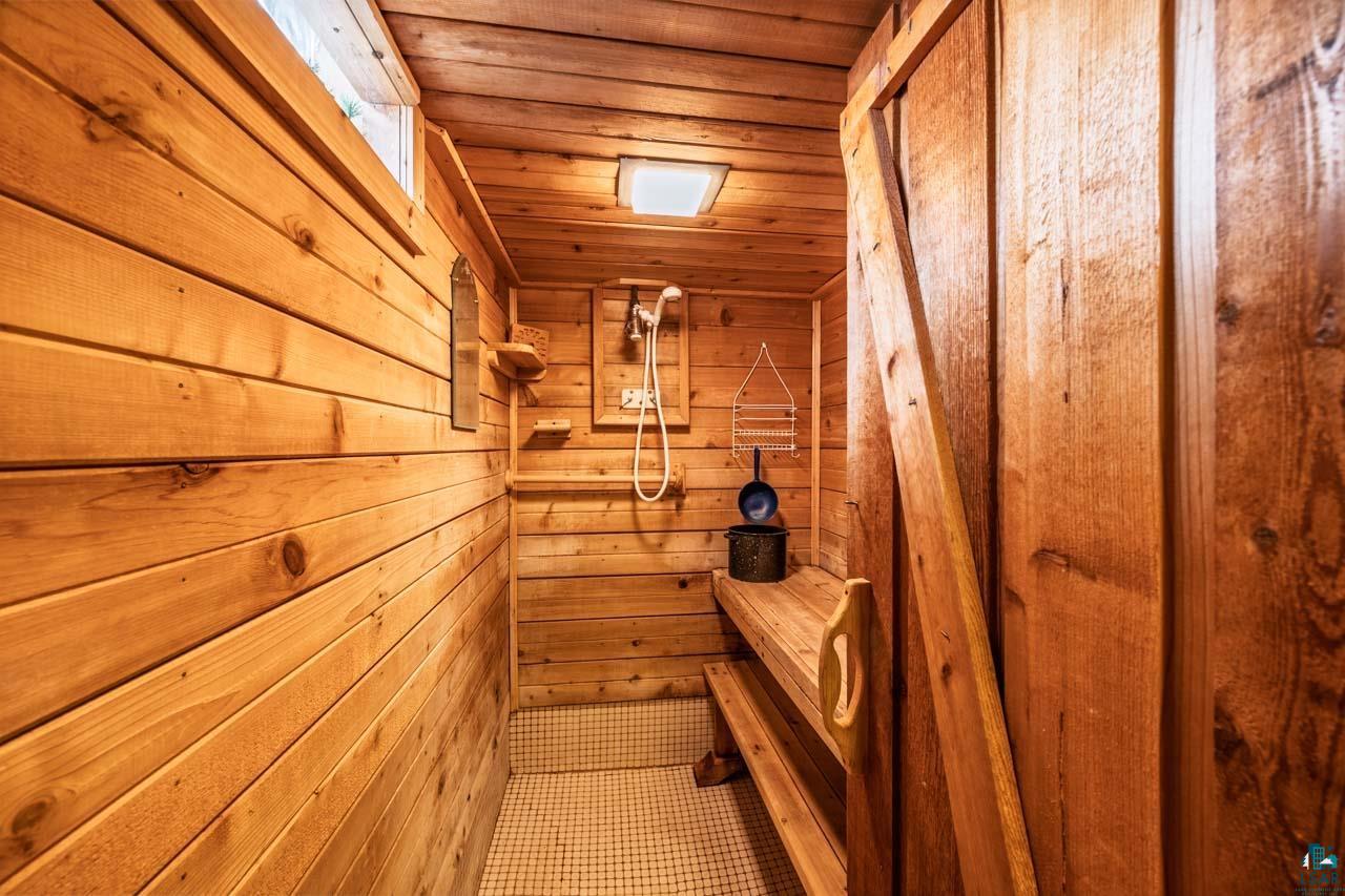 319 Michigan Avenue West Gilbert, MN 55741 - Photo 21 of 48 Wood-paneled interior featuring a built-in bench and a wall-mounted shower fixture
