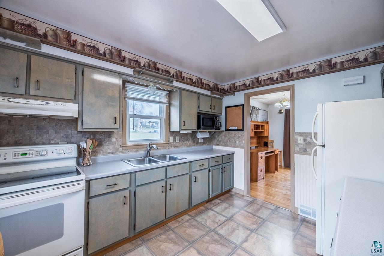 319 Michigan Avenue West Gilbert, MN 55741 - Photo 7 of 48 Kitchen featuring a double basin stainless steel sink, laminate countertops, and tile flooring