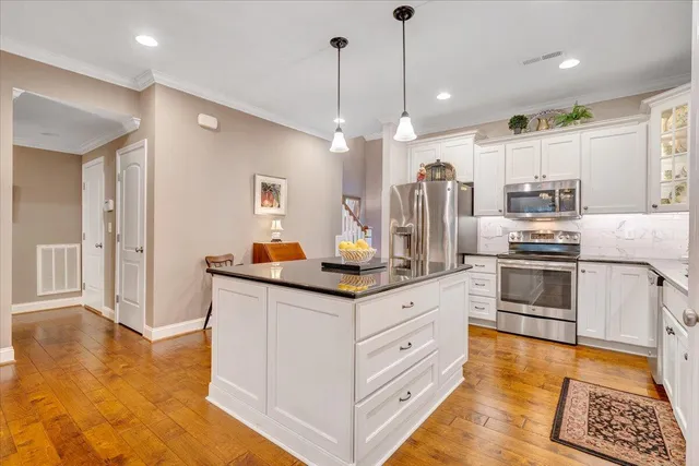 a kitchen with granite countertop white cabinets and white appliances