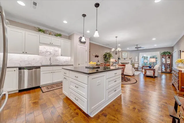 a dining room with furniture a chandelier and wooden floor