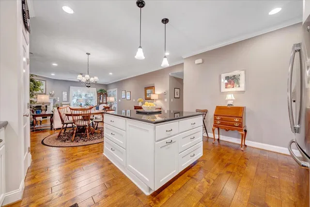 a living room with dining table and a chandelier