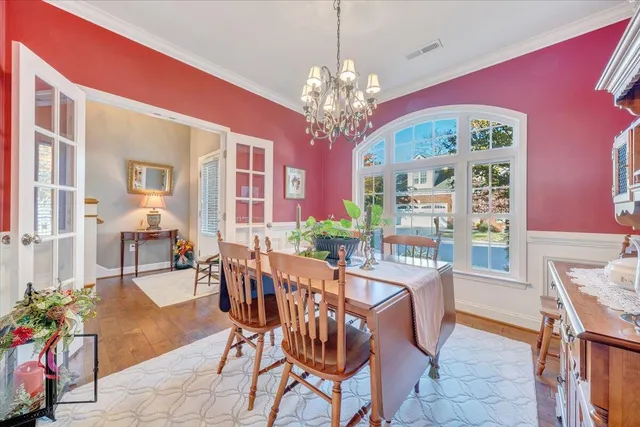 a kitchen with stainless steel appliances granite countertop a refrigerator a oven and white cabinets with wooden floor