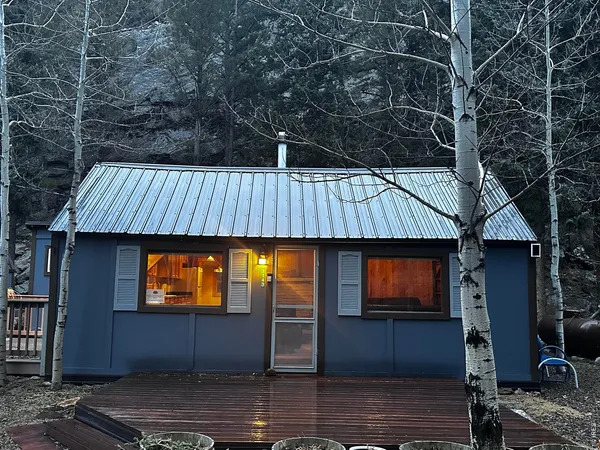 a backyard of a house with table and sofas