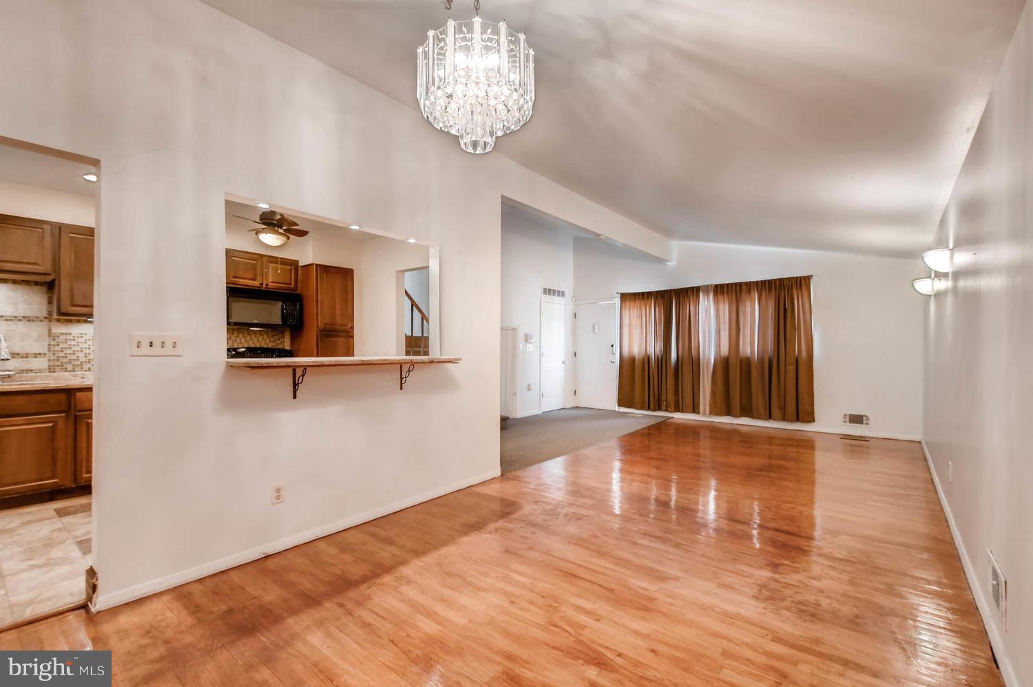 3306 Southgreen Road Baltimore, MD 21244 - Photo 3 of 14 a view of an empty room with wooden floor and a kitchen