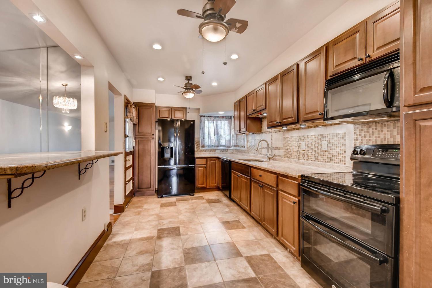 3306 Southgreen Road Baltimore, MD 21244 - Photo 4 of 14 a large kitchen with stainless steel appliances kitchen island granite countertop a refrigerator and a sink