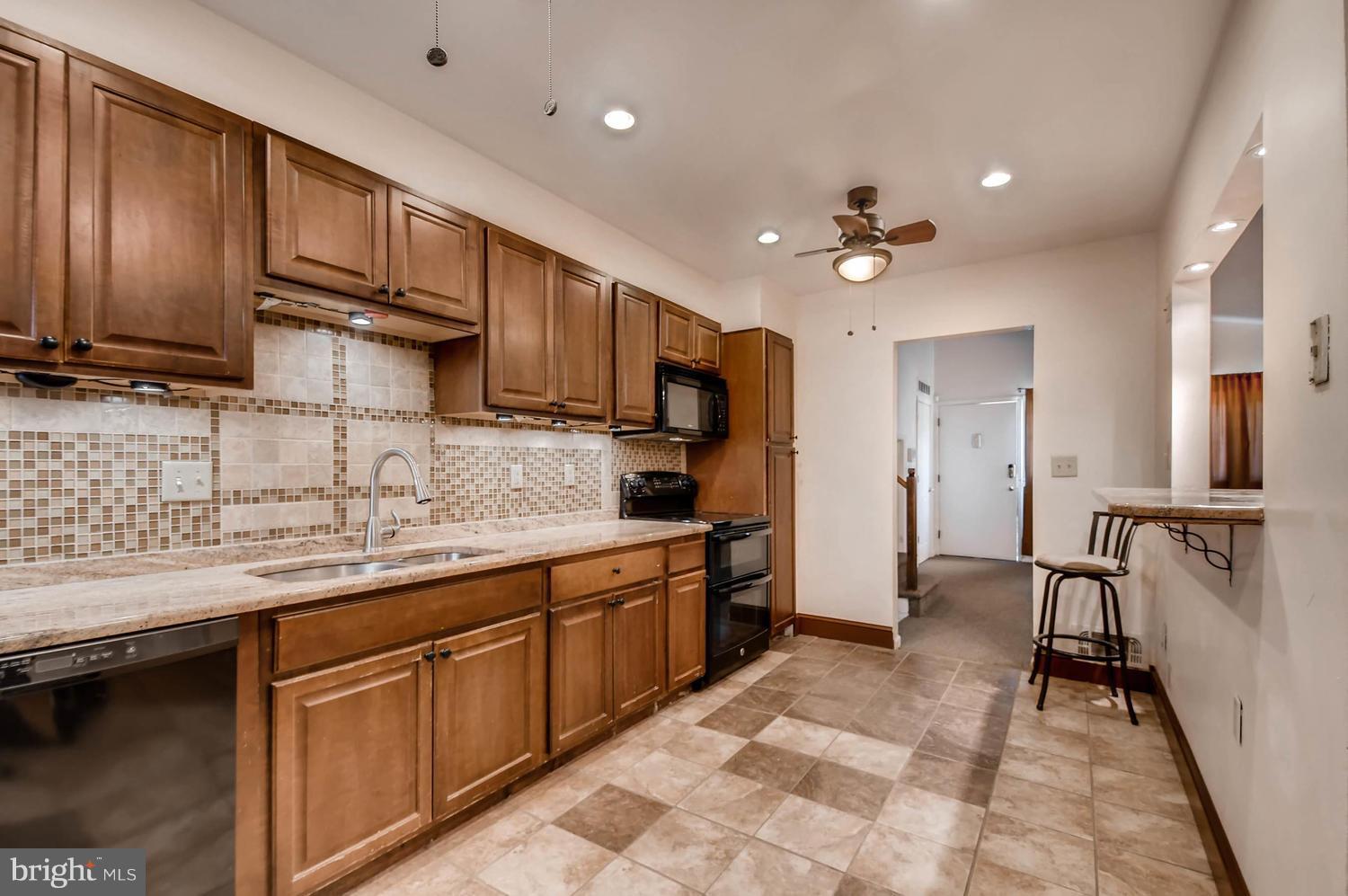 3306 Southgreen Road Baltimore, MD 21244 - Photo 5 of 14 a kitchen with stainless steel appliances granite countertop a sink refrigerator and cabinets