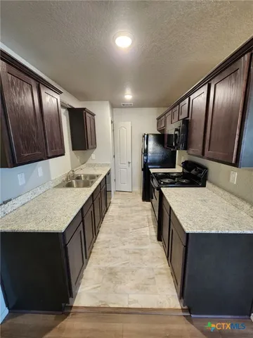 a large kitchen with kitchen island a sink stove and refrigerator