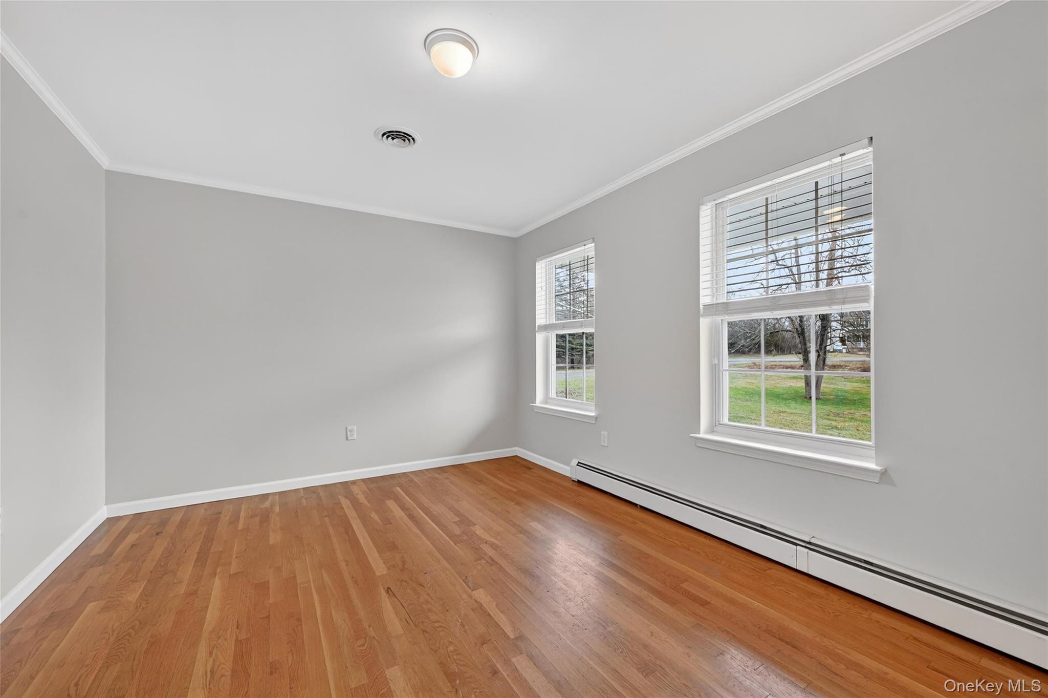 89 James Wilkinson Road Rock Tavern, NY 12575 - Photo 4 of 11 an empty room with wooden floor and windows